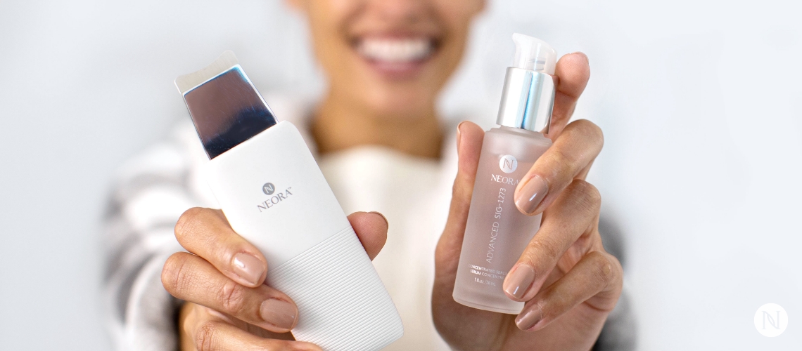 Woman holding up Neora's SIG-SERUM and Skincare device