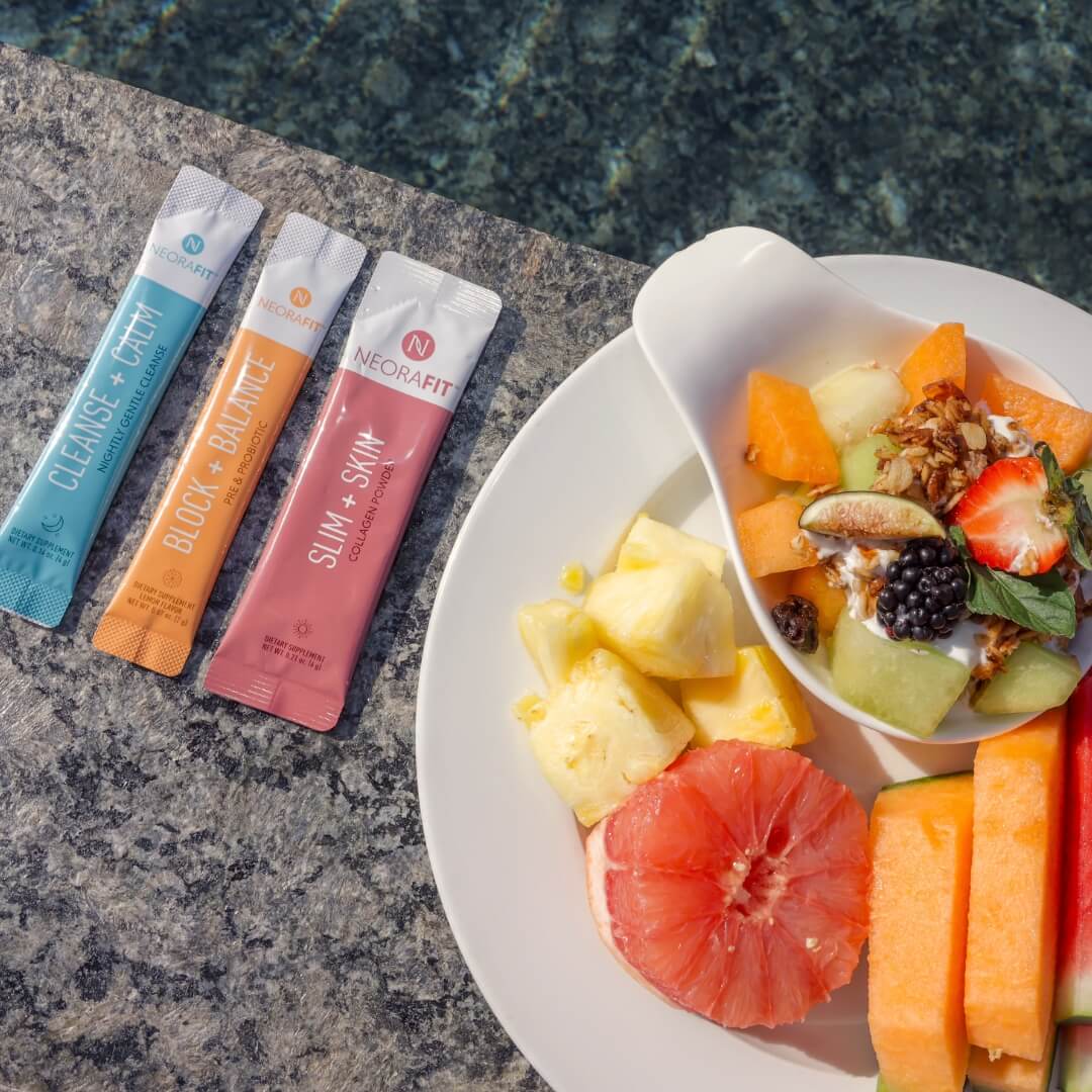 NeoraFit sachets next to a plate of fruit.